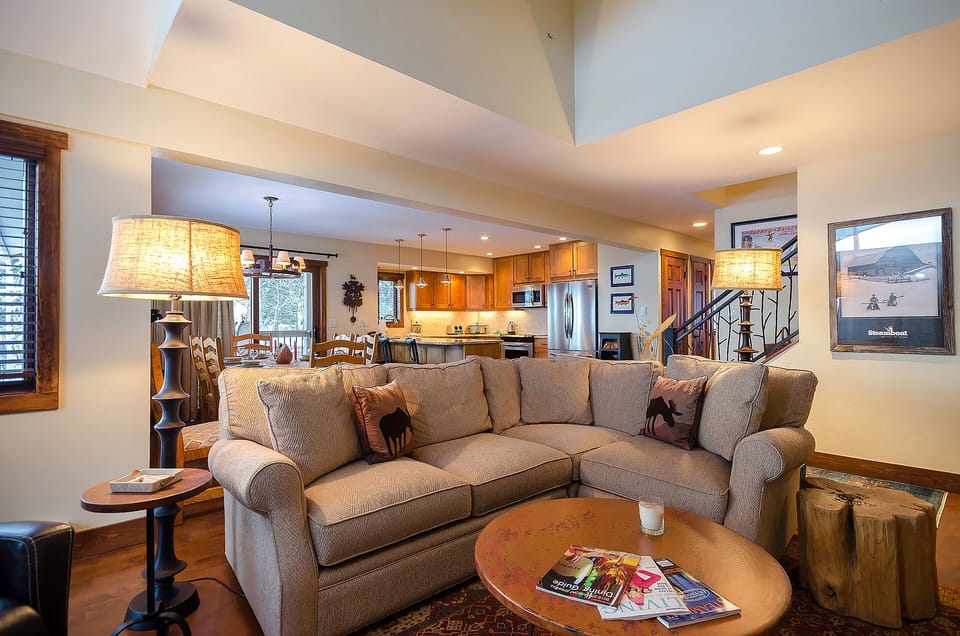 Sink into this plush sectional where warm lighting and rustic touches create your perfect mountain retreat atmosphere.