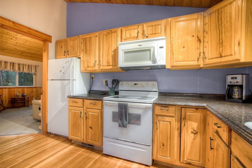 Fully equipped kitchen includes a full-size fridge, microwave, stove/oven, drip coffeemaker, and a dishwasher