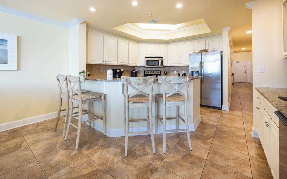 Kitchen area with granite countertops, stainless appliances, and cozy bar seating for a relaxing dining experience