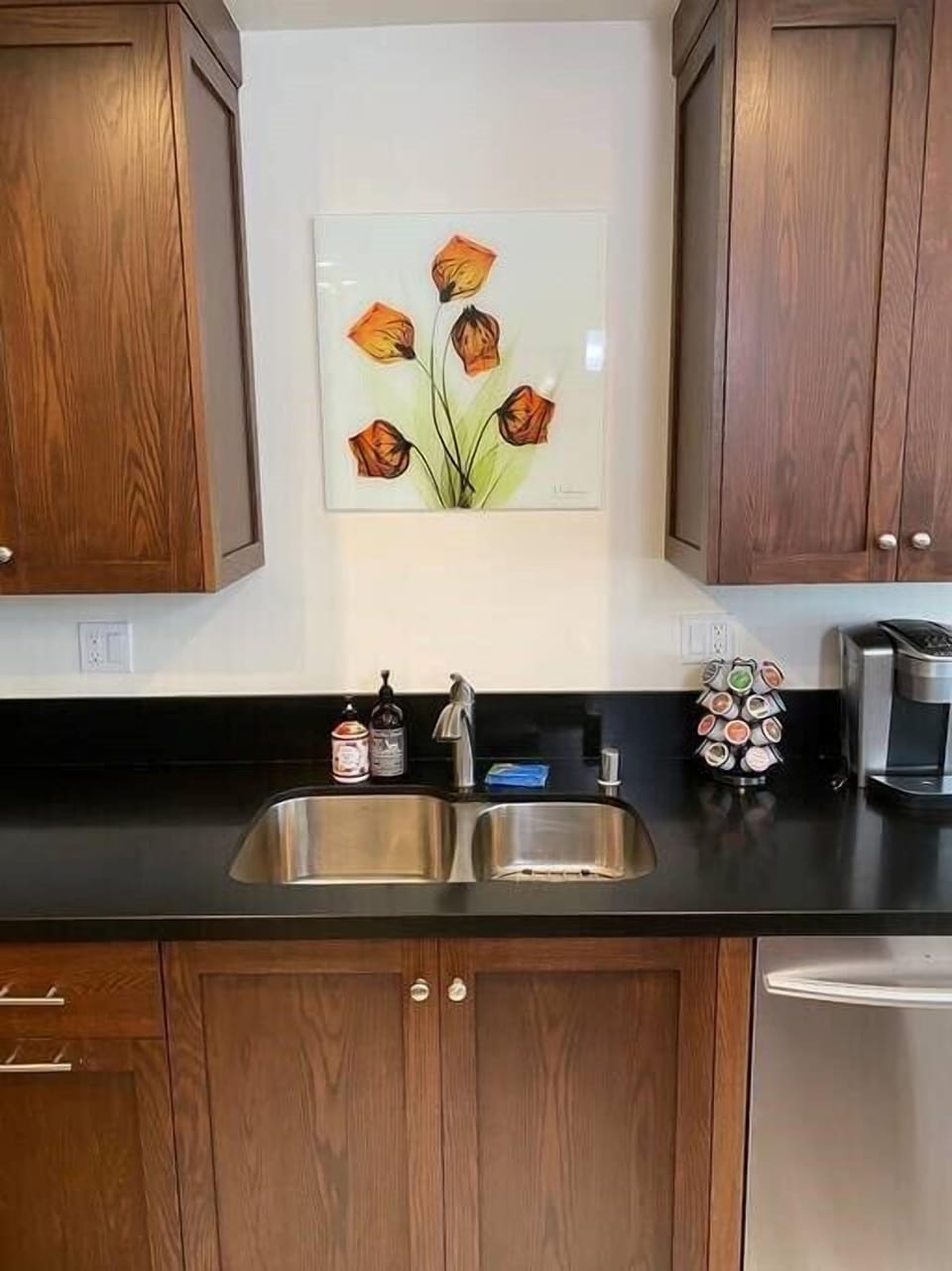 Stainless steel kitchen sink with Keurig coffee maker and a selection of coffees and teas.