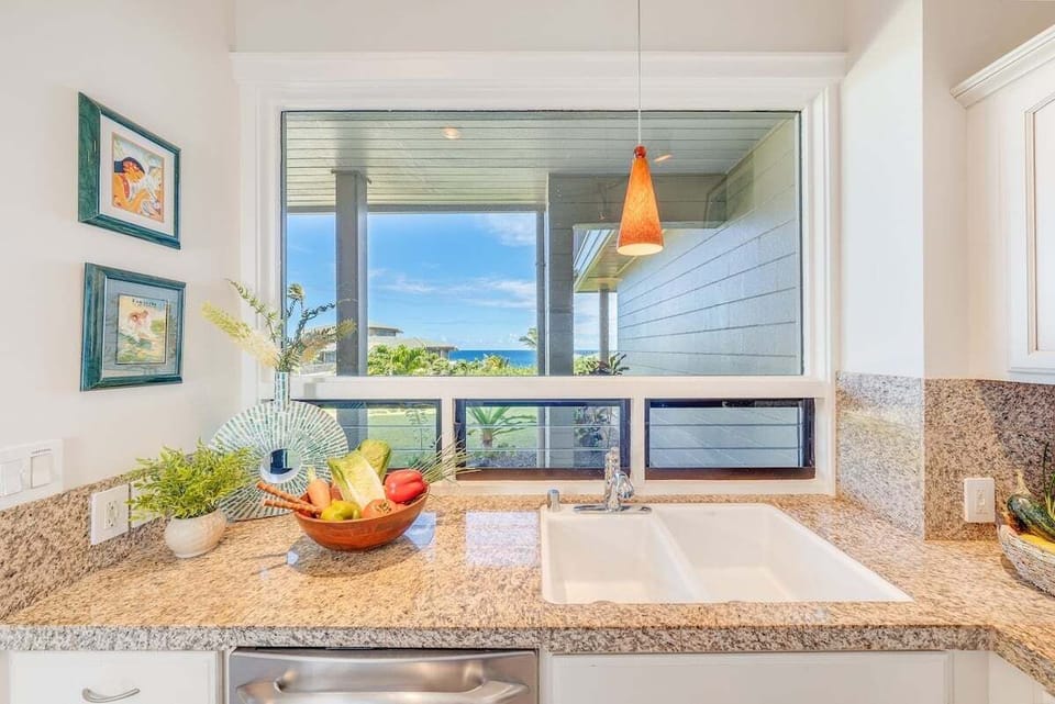 Create memorable meals in a kitchen with a view of the ocean and tropical gardens.