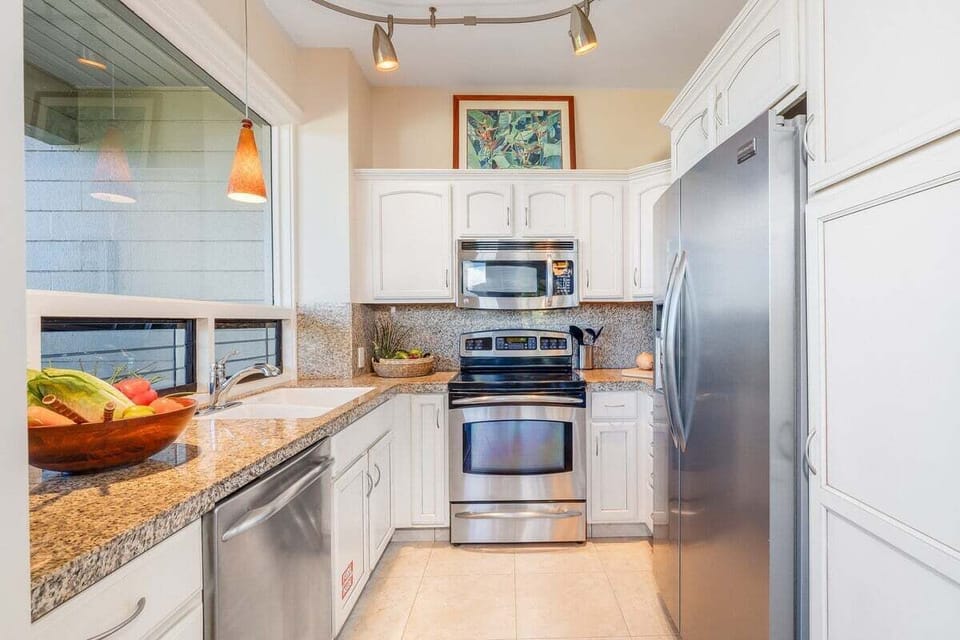 Fully equipped kitchen with stainless steel appliances and granite countertops.
