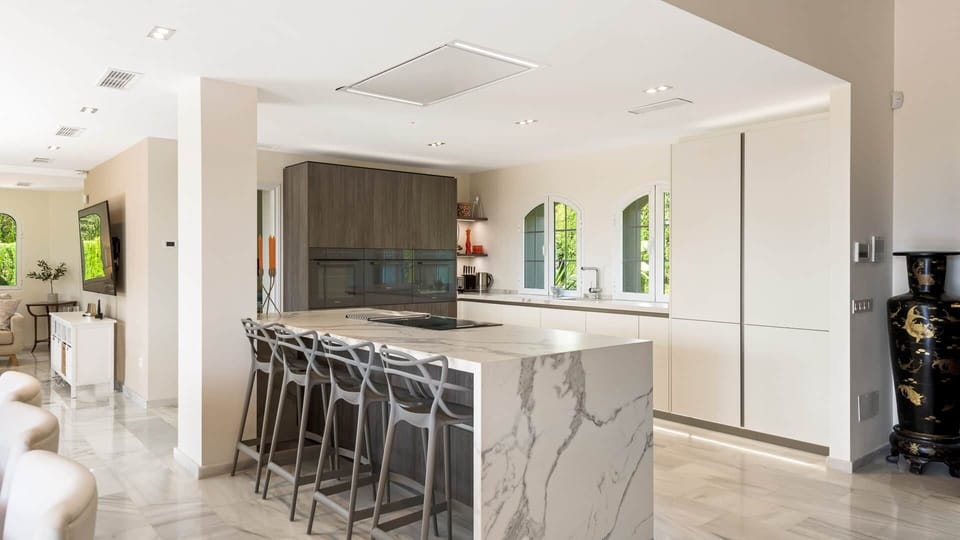 Kitchen seating area and island breakfast bar with garden views. a