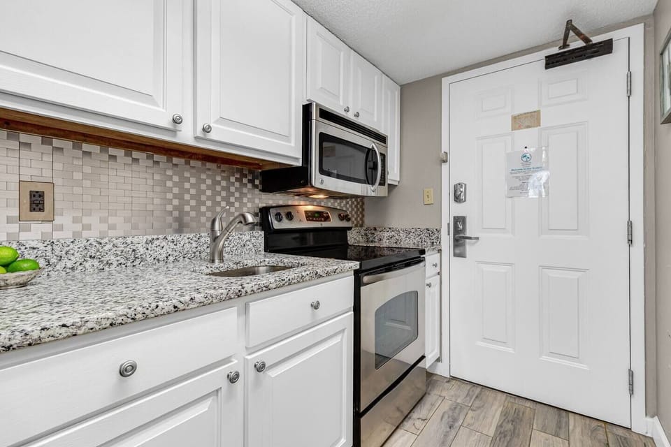 Immerse yourself in a contemporary culinary experience in our suite's kitchen, featuring clean lines, stainless steel appliances, and a minimalist aesthetic.