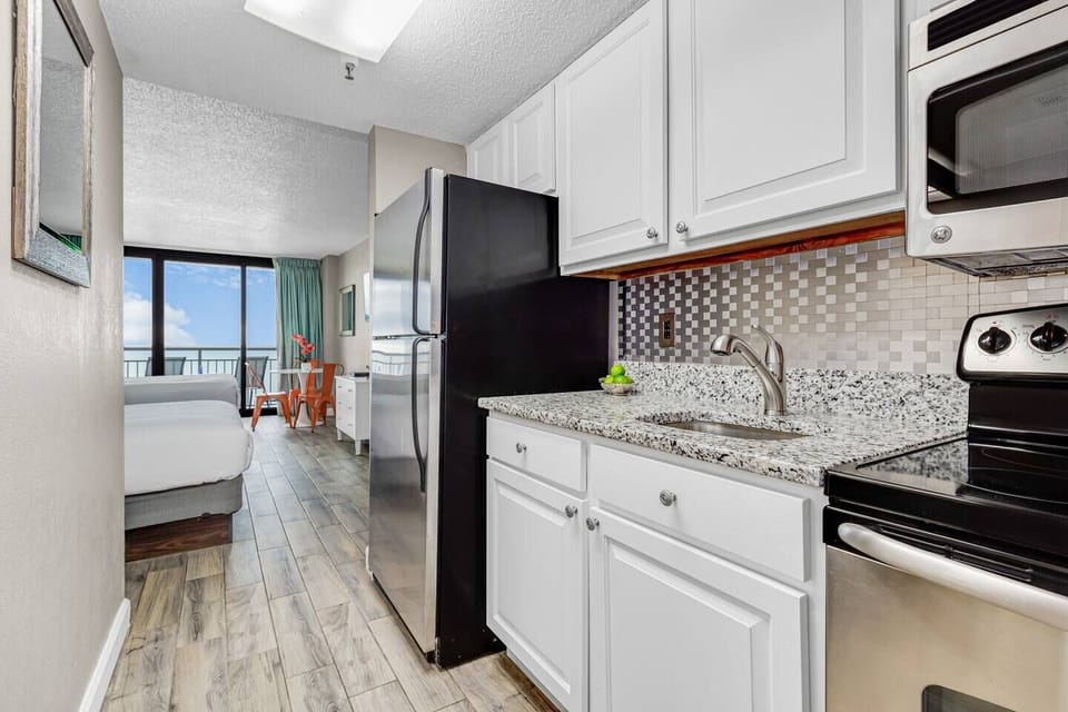 Immerse yourself in a contemporary culinary experience in our suite's kitchen, featuring clean lines, stainless steel appliances, and a minimalist aesthetic.