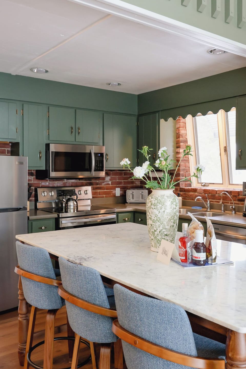 A large anthropologie island with stools to congregate and pour a glass of wine or prepare a meal.