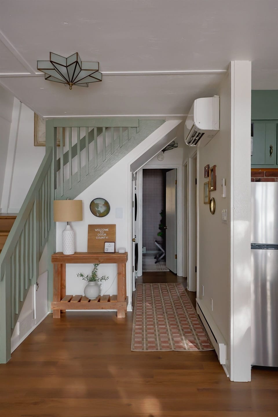 Stairway upstairs and hallway to the two bedrooms on the first floor and downstairs full bath.
