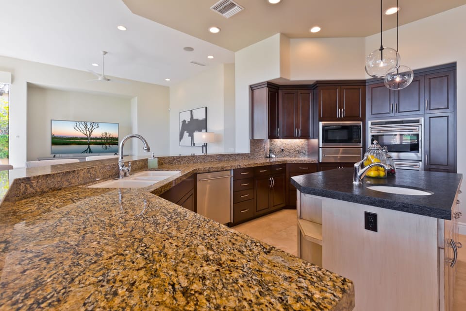 Kitchen with dual ovens, dual dishwashers, large cooktop and walk in pantry.
