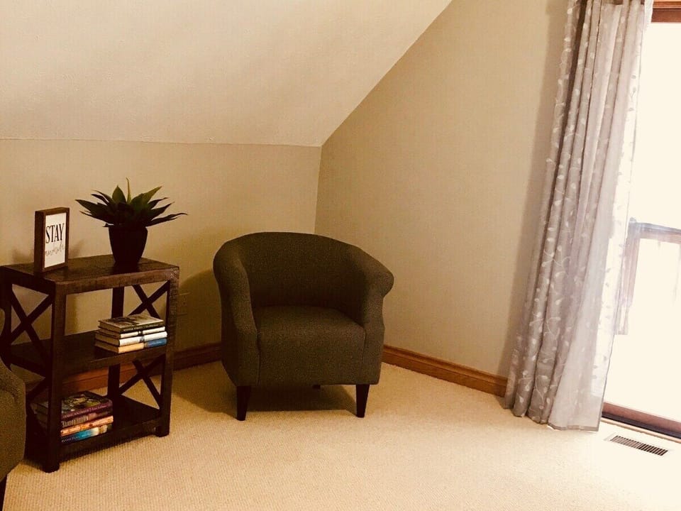 Sitting area in master bedroom near sliding glass doors to balcony