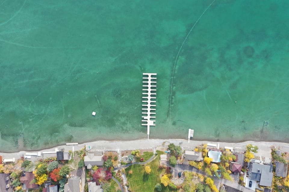 Aerial view of the Mountain Harbor private beach on Whitefish Lake with dock. (Boat slips available with reservation).