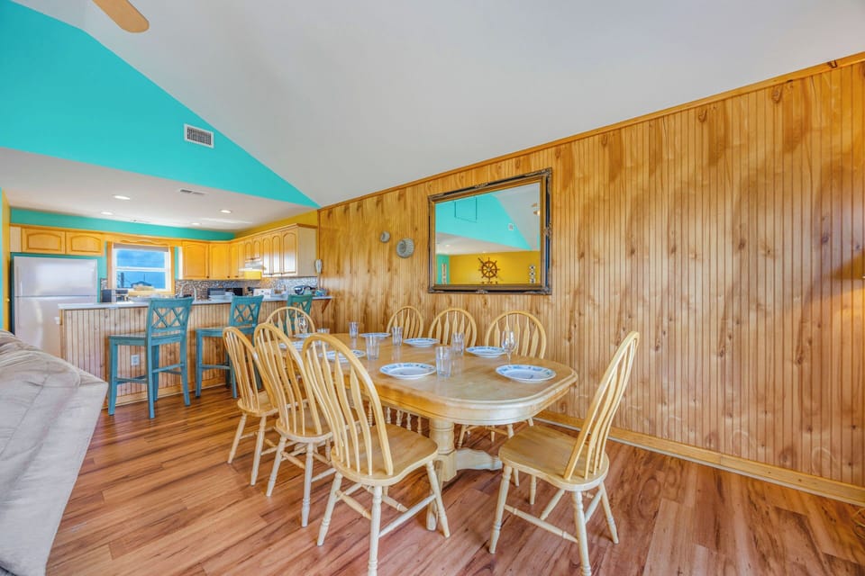 Gather around this spacious dining table where your group can share meals and make memories together in this bright, beachy space with coastal charm.