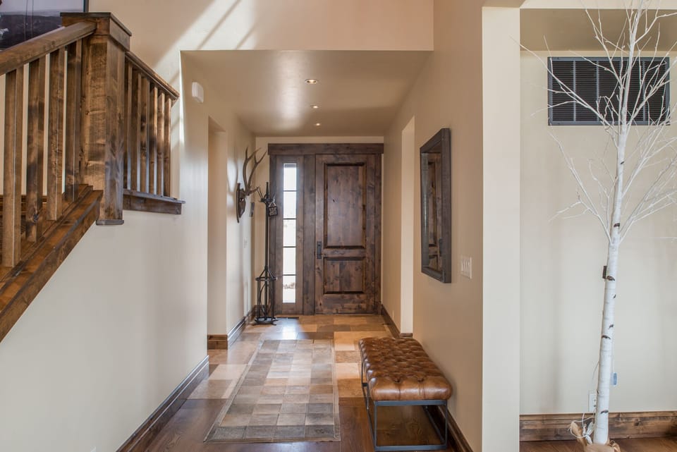 Step into your mountain retreat through the welcoming rustic entryway, where warm wood tones and modern comfort create the perfect balance for your getaway.