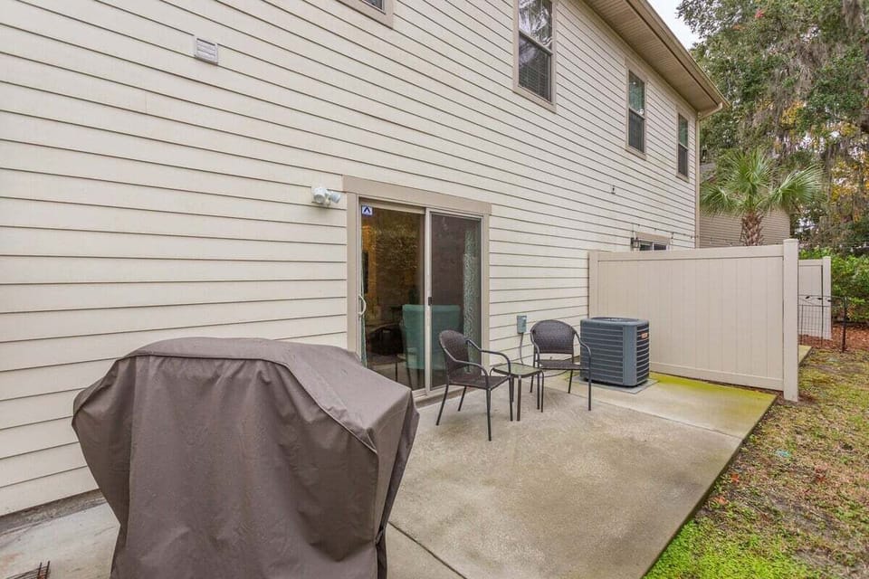 Property backyard patio with covered grill and seating