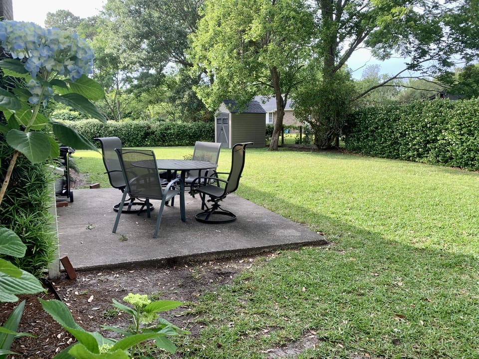 Fenced backyard with patio and seating for four