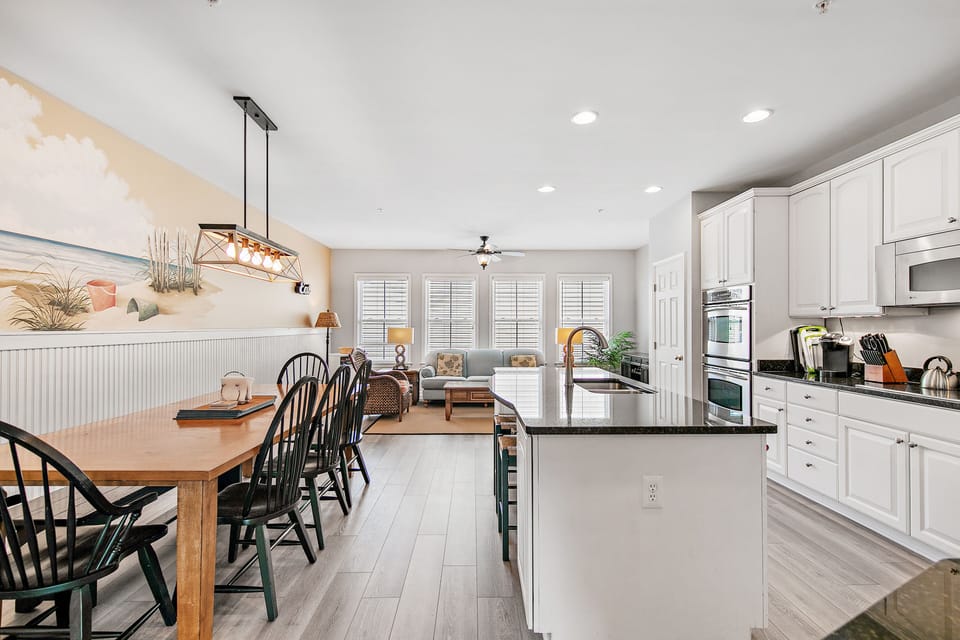 Closeup view of kitchen - large table and island for family meals with sunroom.