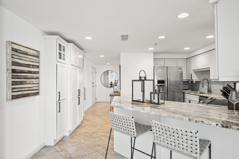 The kitchen features a breakfast bar with seating for two, perfect for casual meals, morning coffee, or quick bites.