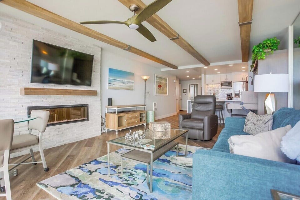 Living room with a queen size sofa bed, ceiling fan, fireplace, Smart TV, recliner, and dining area