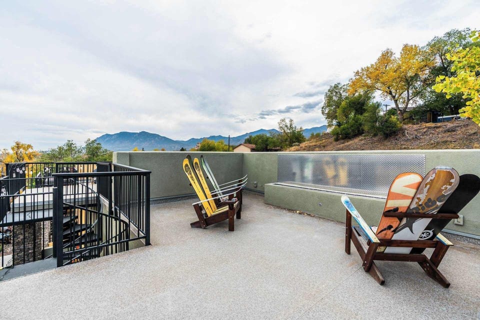 Fire pit rooftop with Adirondack-style chairs and wide views beyond the railing. Start slow mornings outside or wind down in the fresh air, soaking in the open sky and distant landscape from this relaxed outdoor perch.