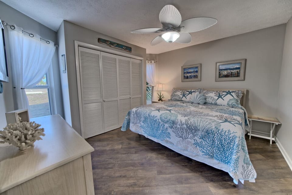 Bask in natural light and coastal charm in this spacious bedroom, complete with a plush king-sized bed and airy decor for ultimate relaxation