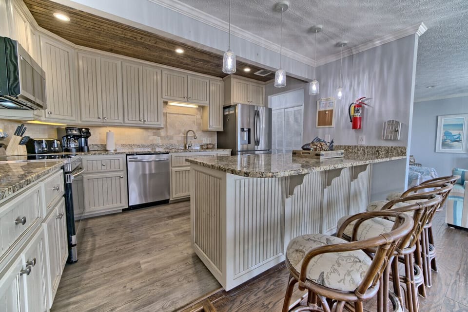 Cook with ease in this spacious kitchen, featuring granite countertops and an open layout that flows seamlessly into breathtaking ocean views