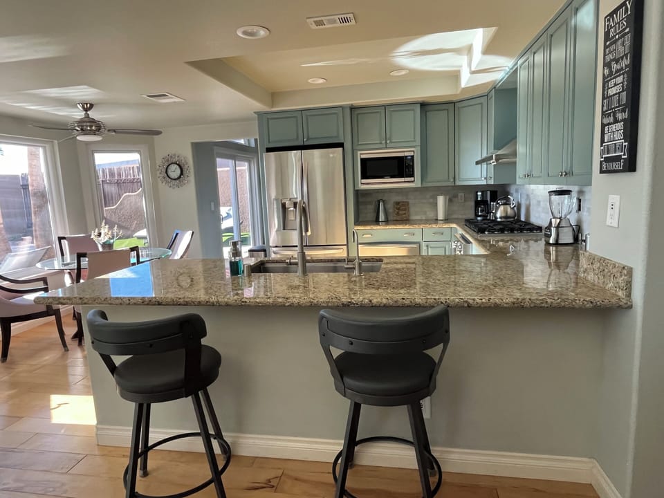 stovetop, refrigerator,coffee maker, microwave, kitchen island with seating