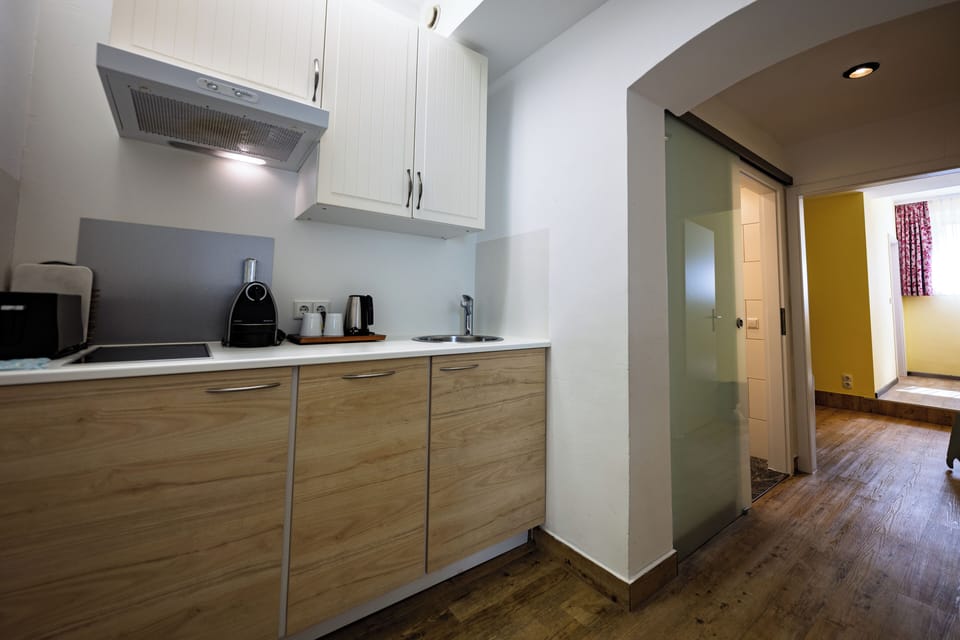 Standard Apartment, Multiple Beds (Cozy Sitting Corner) | Private kitchen | Coffee/tea maker, eco-friendly cleaning products, dining tables