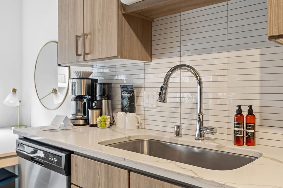 Your modern kitchen awaits with sleek marble counters, quality appliances, and thoughtful touches like premium coffee and artisan soaps for your comfort.