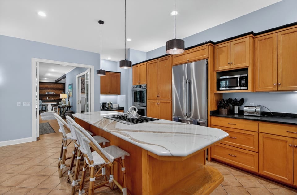 Gather around this spacious kitchen island where your group can prep meals together, share stories, and enjoy easy access to modern appliances and ample counter space for your culinary adventures.