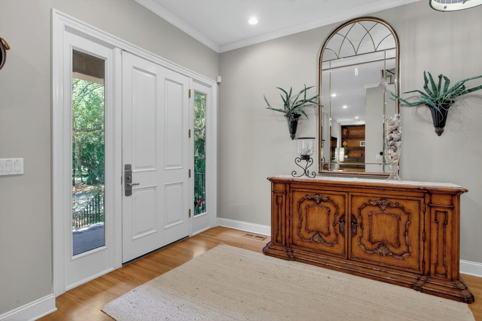 Step through the door into your welcoming entryway with warm wood floors, natural light from side windows, and elegant décor that sets the tone for your relaxing stay.