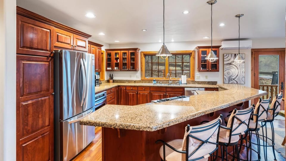 Fully stocked open concept kitchen with breakfast bar seating for 4, two ovens, gas stove, brand new appliances, drip pot coffee maker, and pantry.