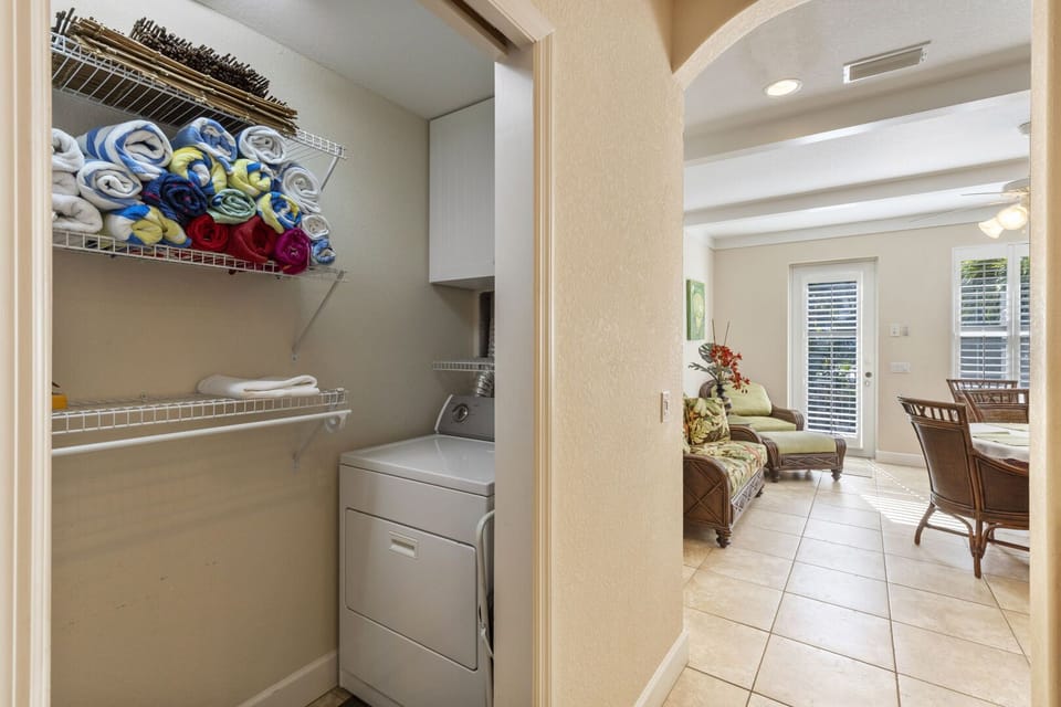 Hallway with washer and dryer, built-in storage, and long corridor with tile flooring