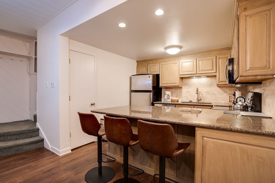 Your fully equipped kitchen features granite countertops, modern appliances, and a breakfast bar where you can enjoy morning coffee.