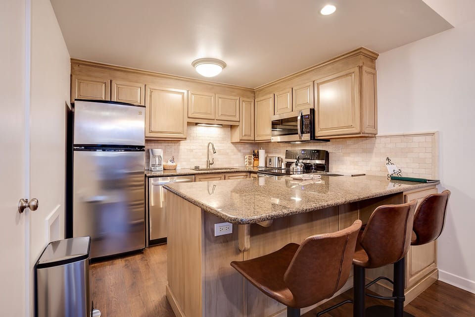 Your fully equipped kitchen invites culinary adventures with granite counters, stainless appliances, and a breakfast bar perfect for morning coffee.