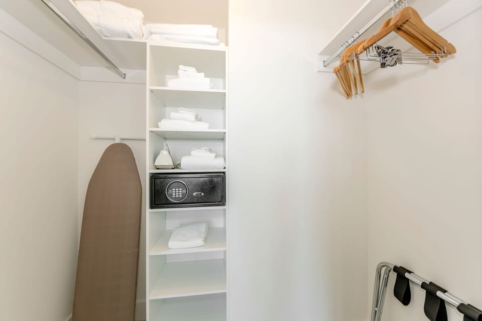 Walk-in closet: with hangers, safe box and ironing board.