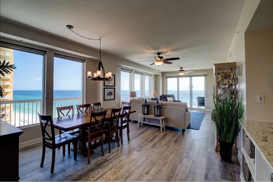Relax in your bright, open living space where ocean views stretch endlessly beyond floor-to-ceiling windows, creating the perfect backdrop for memorable meals.