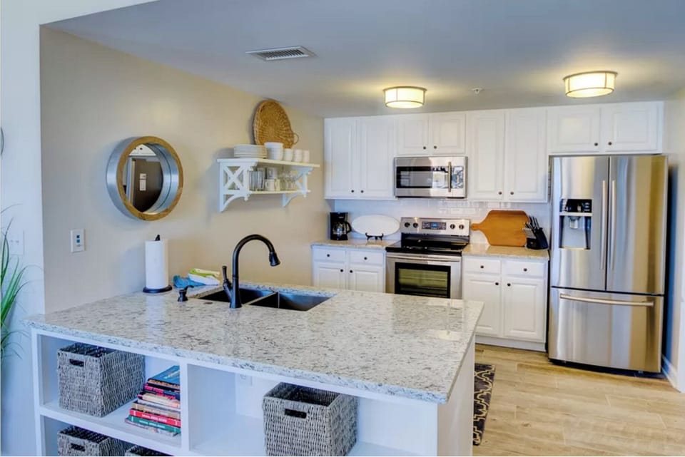 Cook your favorite meals in this bright, fully-equipped kitchen featuring granite countertops, stainless steel appliances, and thoughtful coastal touches.