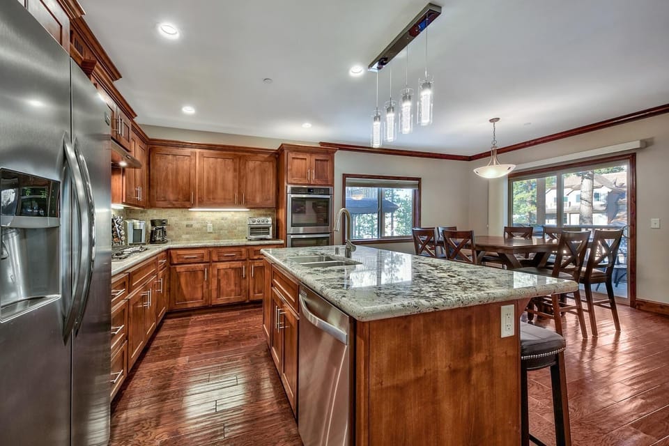 Your gourmet kitchen awaits with granite countertops, stainless steel appliances, and rich hardwood floors flowing into the elegant dining space.