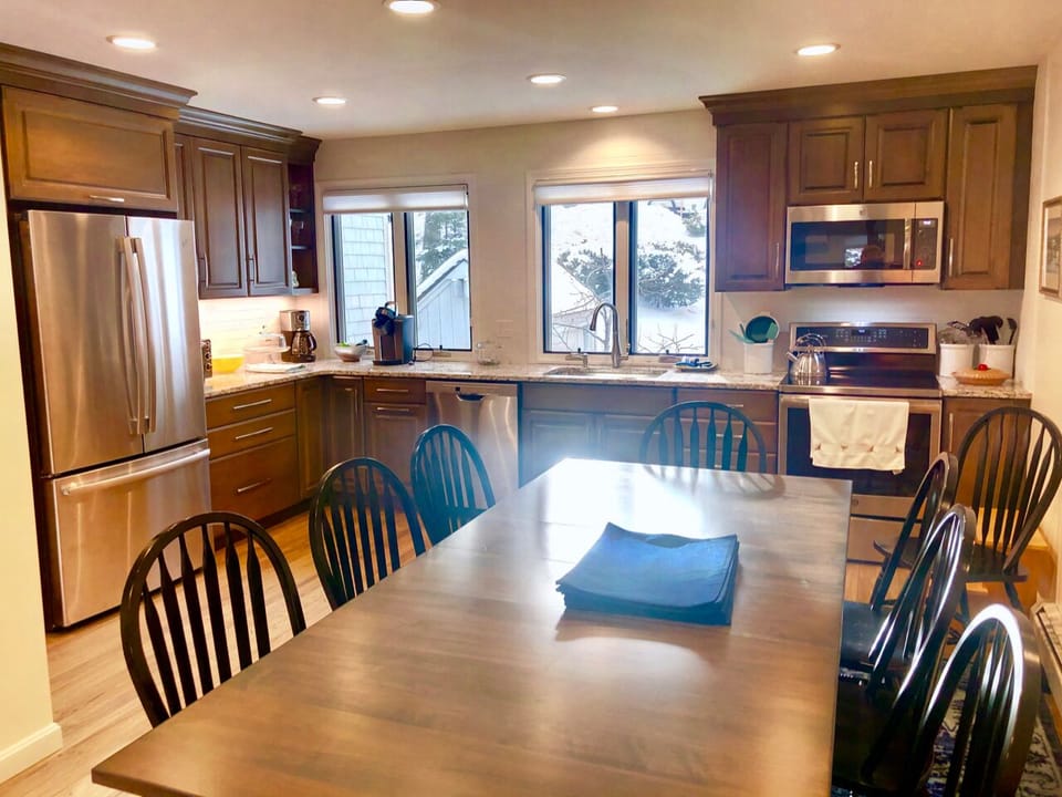 It features an expanded kitchen and dining area with a large dining table that seats 10 — perfect for gathering over a home-cooked meal