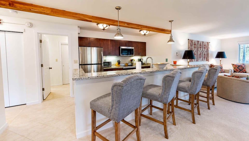 Gather around this spacious kitchen island where granite countertops and stainless appliances set the stage for your group meals and morning coffee rituals together.