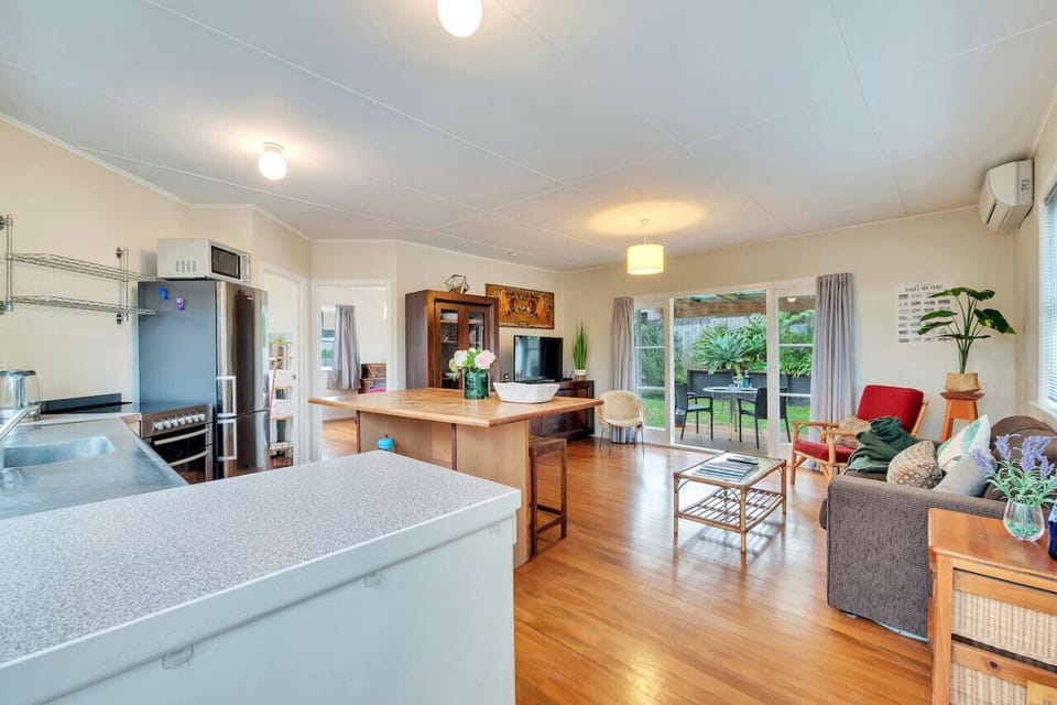 The open-plan living spaces include the kitchen, casual seating at the breakfast bar, and living room.
