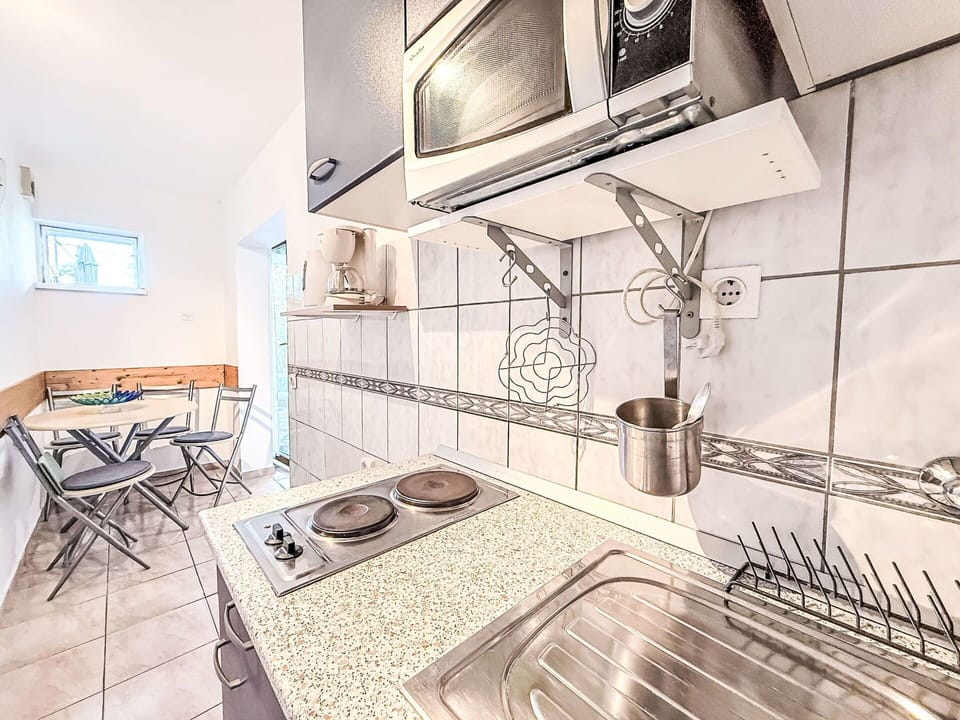 Flooring, Floor, Apartment, Chair, Kitchen, Kitchen & Dining Room Table, Major Appliance, Countertop, Wood Stain, Tile