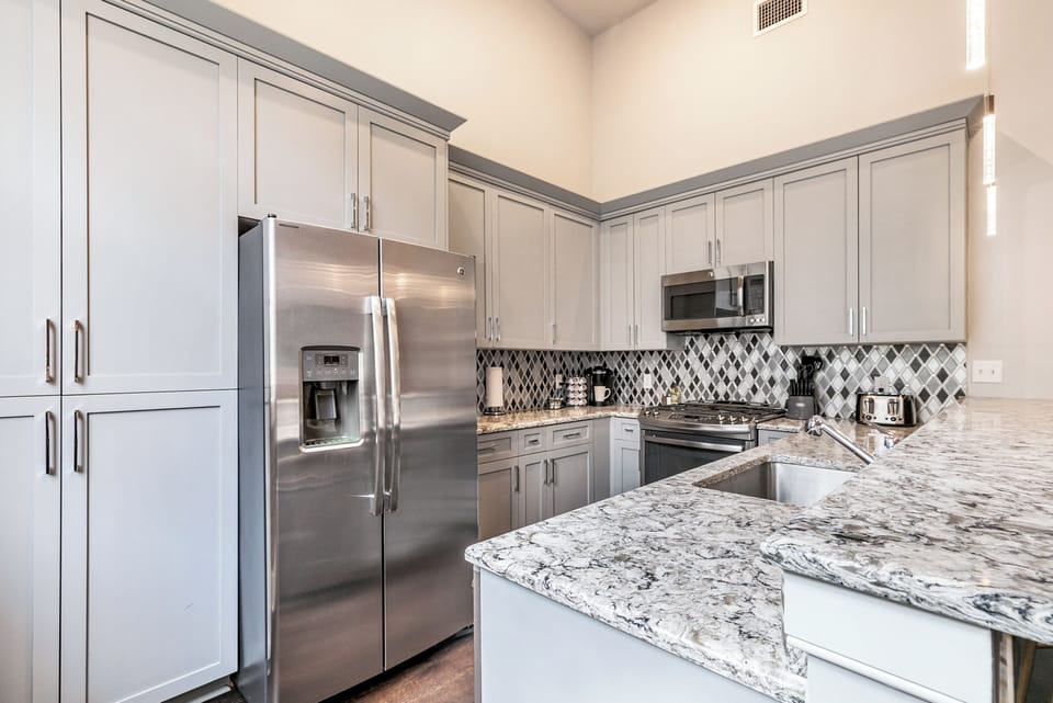 Cook and dine easily in the fully stocked kitchen, equipped with all stainless steel appliances, gas range, basic cookware, and a dining area for a comfortable meal at home. Entertain at the bar with seating for four.