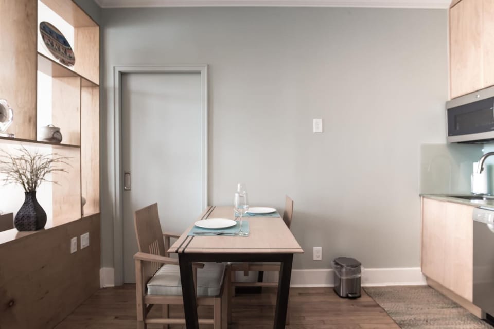 Dining area, Kitchenette with microwave, fridge, Keurig coffee maker, glasses, plates, and cutlery
