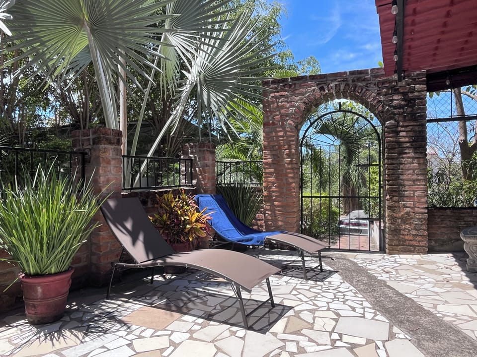 Terrasse privée avec transats au cœur d’un jardin tropical