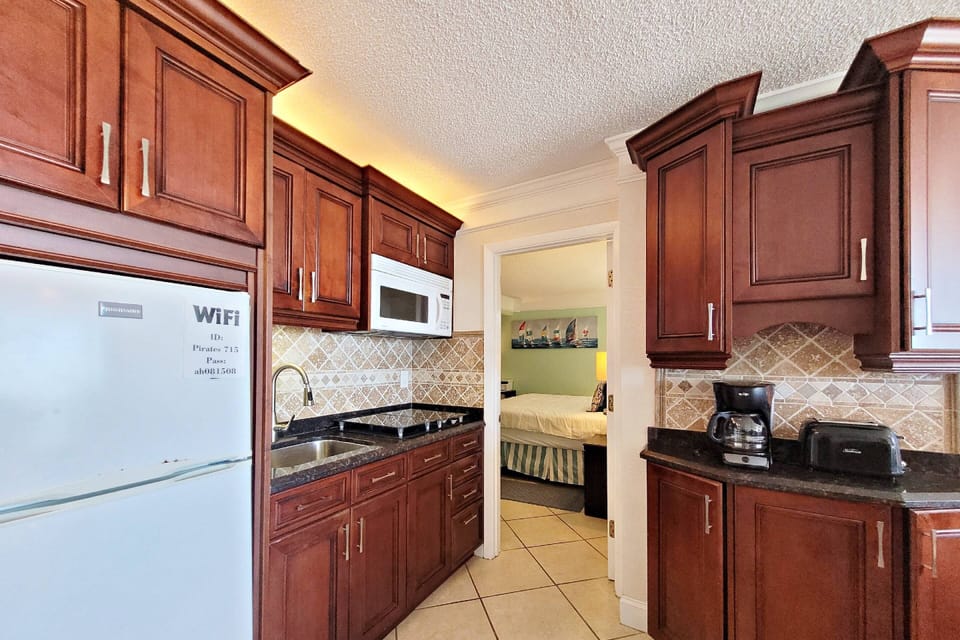 Refrigerator, 4 burner stove top, microwave, toaster oven, Keurig, regular coffee pot maker, crockpot, waffle maker, cookware, plates, cups.