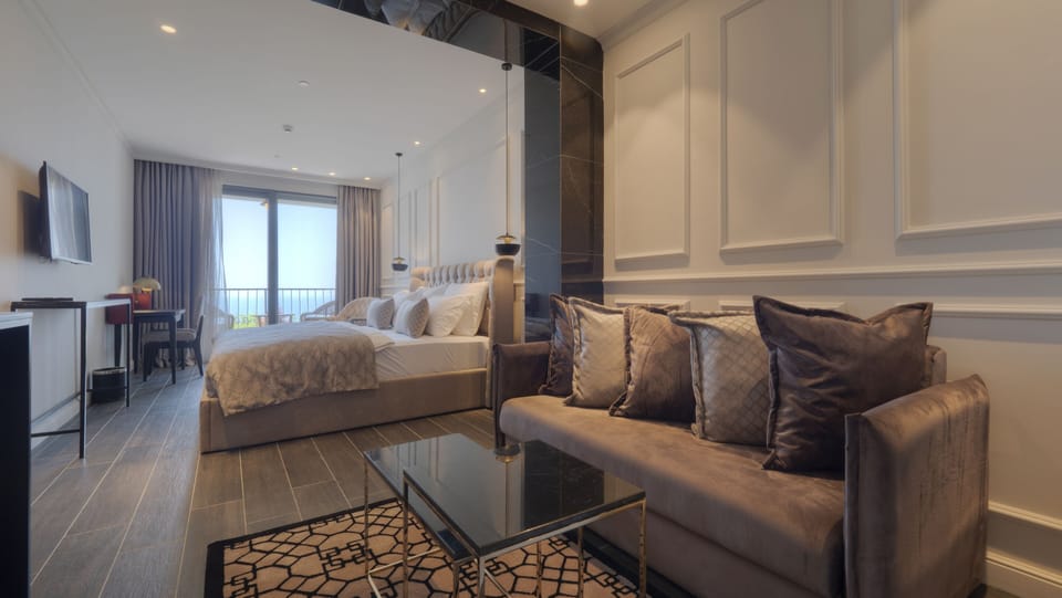 Deluxe Room, Balcony, Sea View | Minibar, in-room safe, desk, laptop workspace