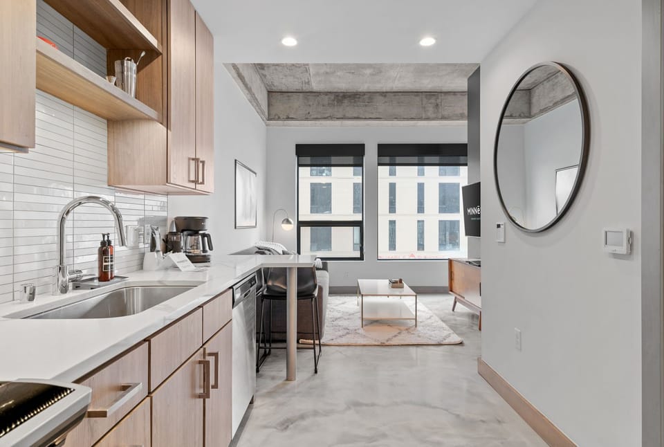Your sleek kitchen flows seamlessly into a bright living space with modern finishes and city views through expansive windows.