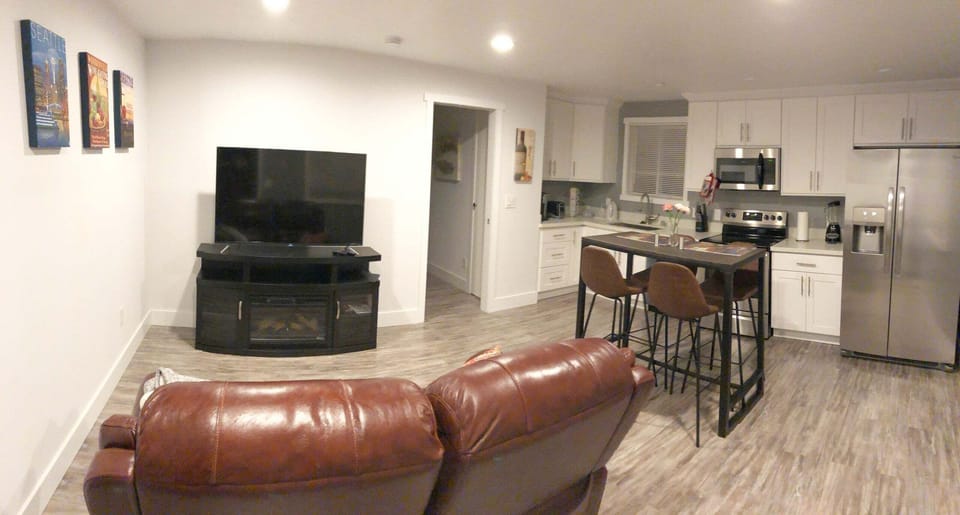 Panorama photo of the living room,  bar/dinette, and kitchen areas.