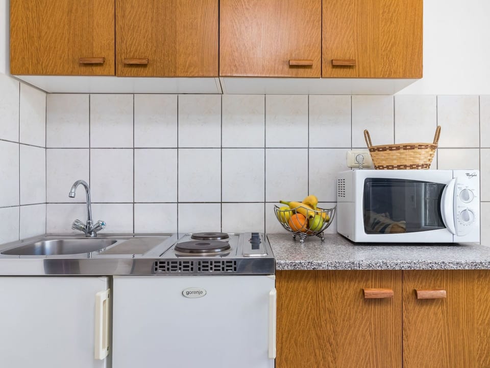 Countertop, Kitchen, Cabinetry, Room, Furniture, Tile, Property, Yellow, Microwave Oven, Major Appliance