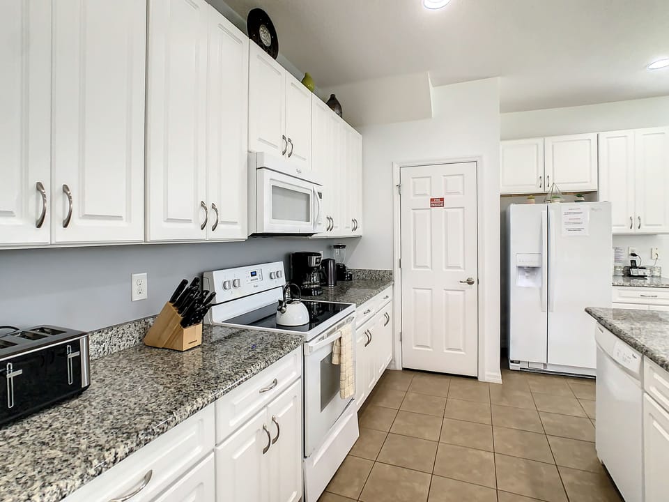 Fully equipped modern kitchen with granite countertops and ample storage space.